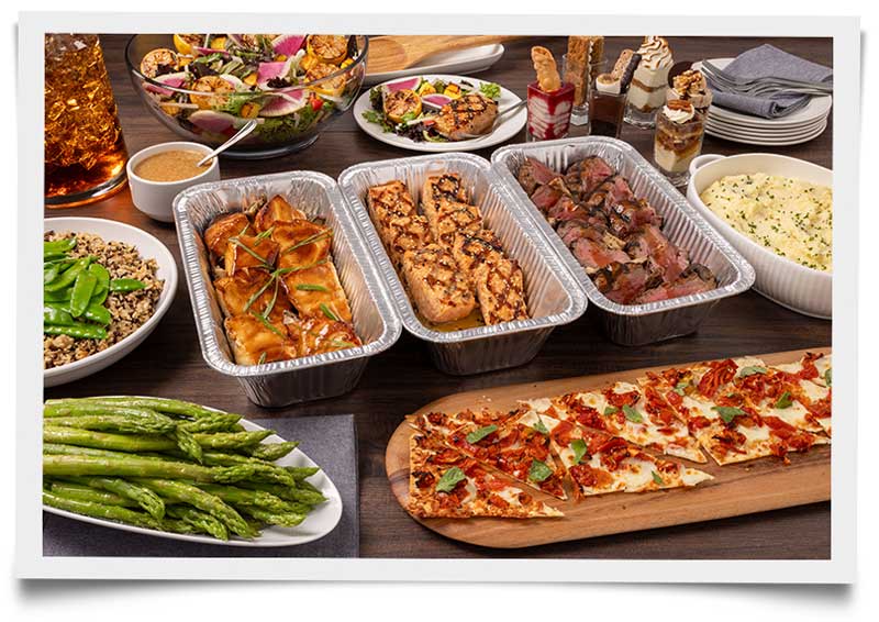 Various Seasons 52 dishes including salads, entrees, and desserts arranged for catering presentation